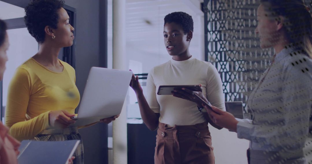 Diverse Team Discussing Ideas Indoors with Digital Devices