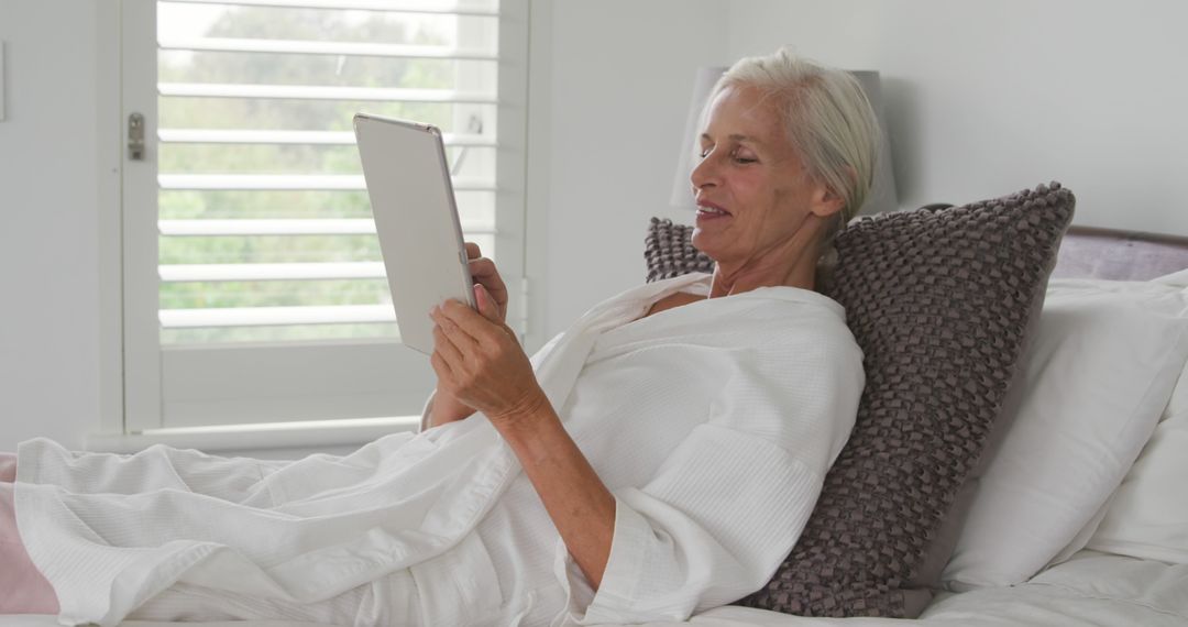 Senior Woman Relaxing in Bed Using Digital Tablet - Free Images, Stock Photos and Pictures on Pikwizard.com