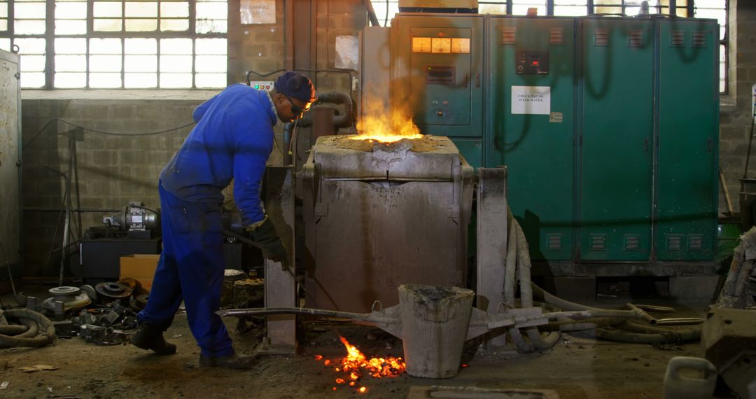 Worker in Blue Overall Operating Industrial Furnace Casting Mold - Free Images, Stock Photos and Pictures on Pikwizard.com