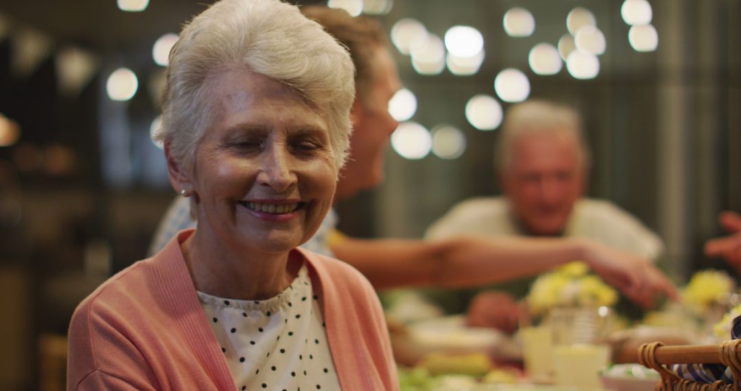 Happy Elderly Woman Smiling During Family Dinner Gathering - Free Images, Stock Photos and Pictures on Pikwizard.com