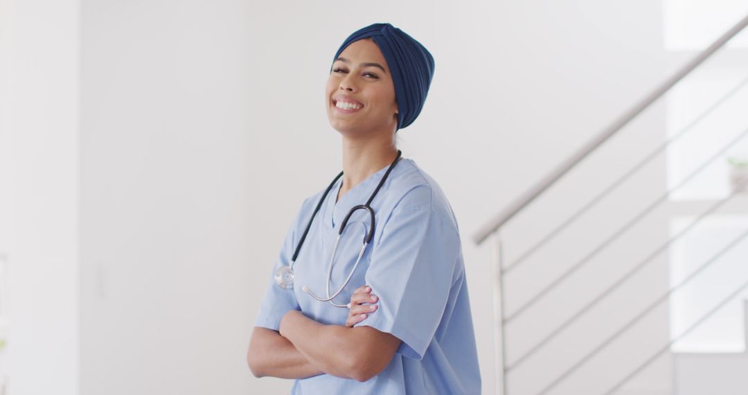 Image of happy biracial female doctor in hijab looking at camera - Free Images, Stock Photos and Pictures on Pikwizard.com
