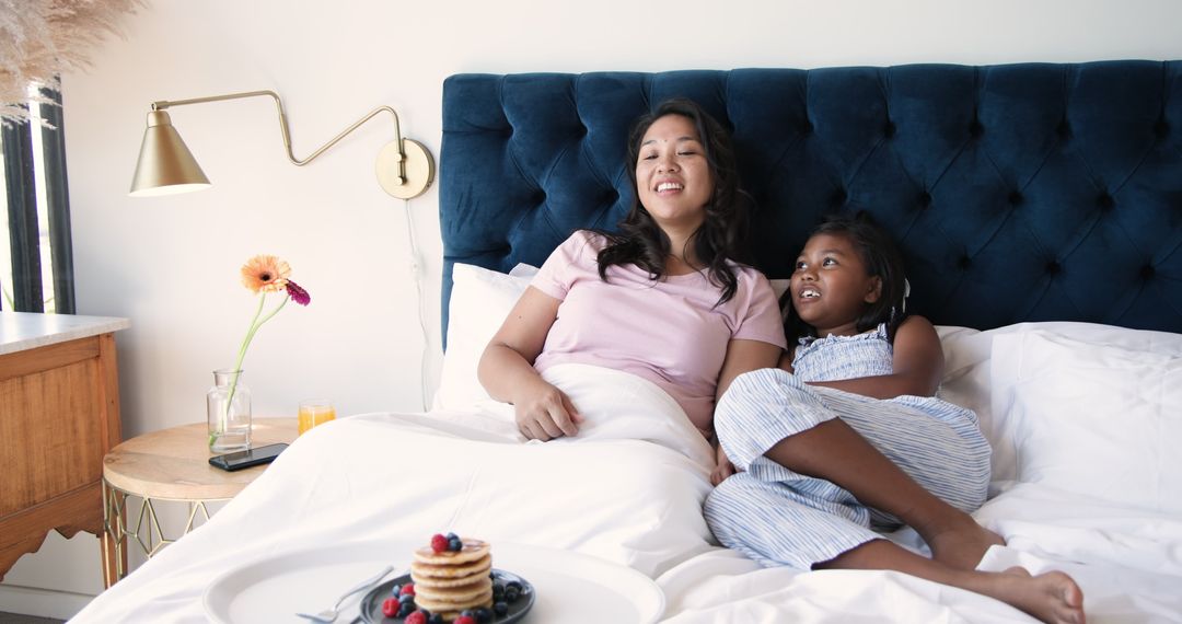 Mother and Daughter Enjoying Breakfast in Bed Together