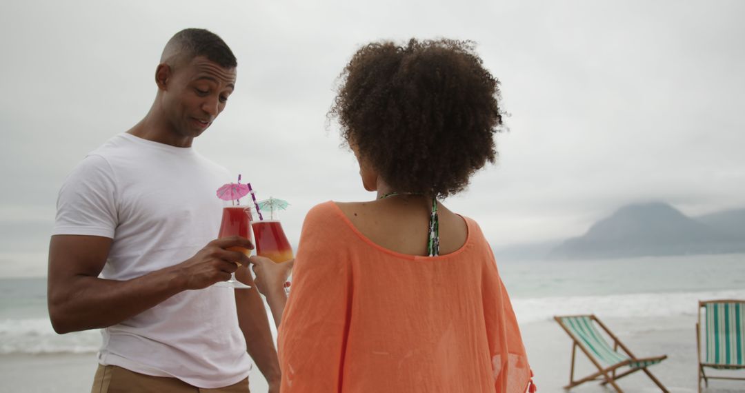 Couple enjoying tropical drinks on a beach vacation - Free Images, Stock Photos and Pictures on Pikwizard.com