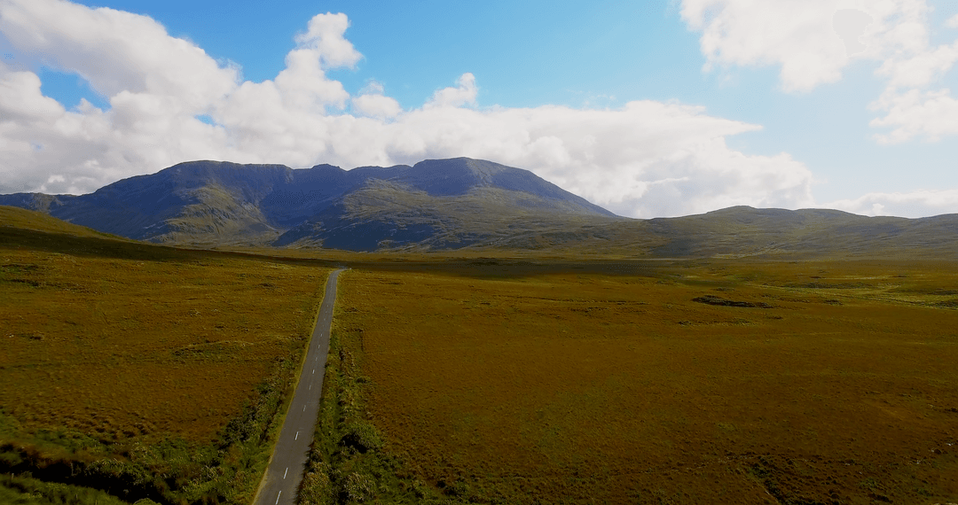 Transparent Open Road Through Lush Green Countryside With Mountains