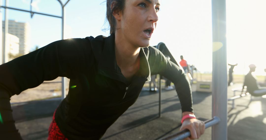 Focused Woman Exercising on Bars during Outdoor Workout Session - Free Images, Stock Photos and Pictures on Pikwizard.com