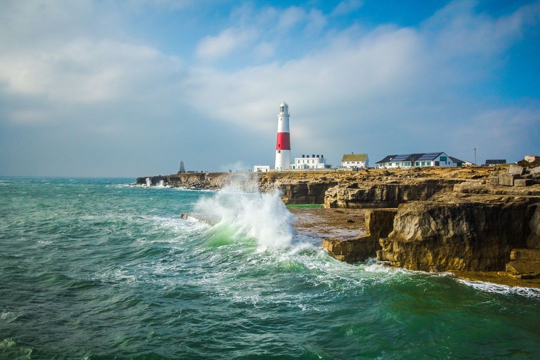 Waves Crashing Against Cliffs by Lighthouse in Coastal Landscape - Free Images, Stock Photos and Pictures on Pikwizard.com