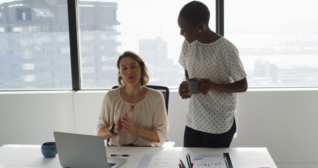 Multiracial Businesswomen Discussing Project at Desk in Modern Office - Free Images, Stock Photos and Pictures on Pikwizard.com