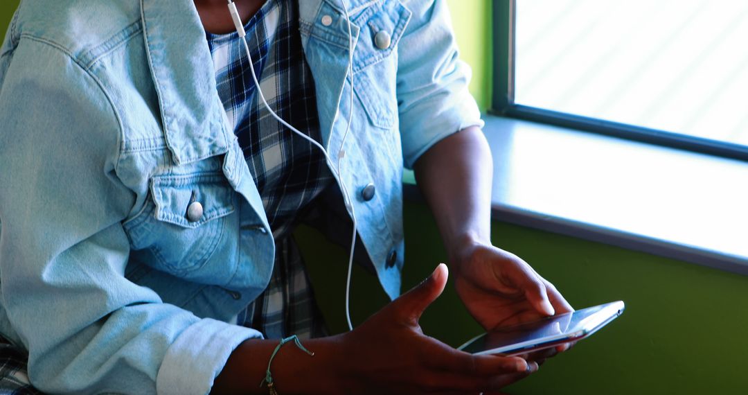 Young person enjoying music on smartphone with headphones - Free Images, Stock Photos and Pictures on Pikwizard.com