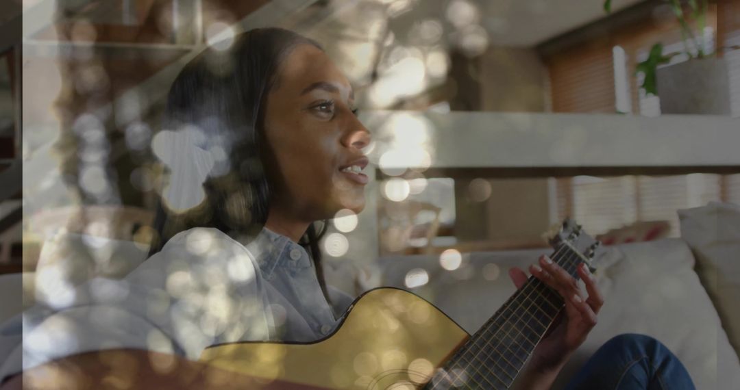 Woman Playing Guitar on Couch with Ethereal Bokeh Lights