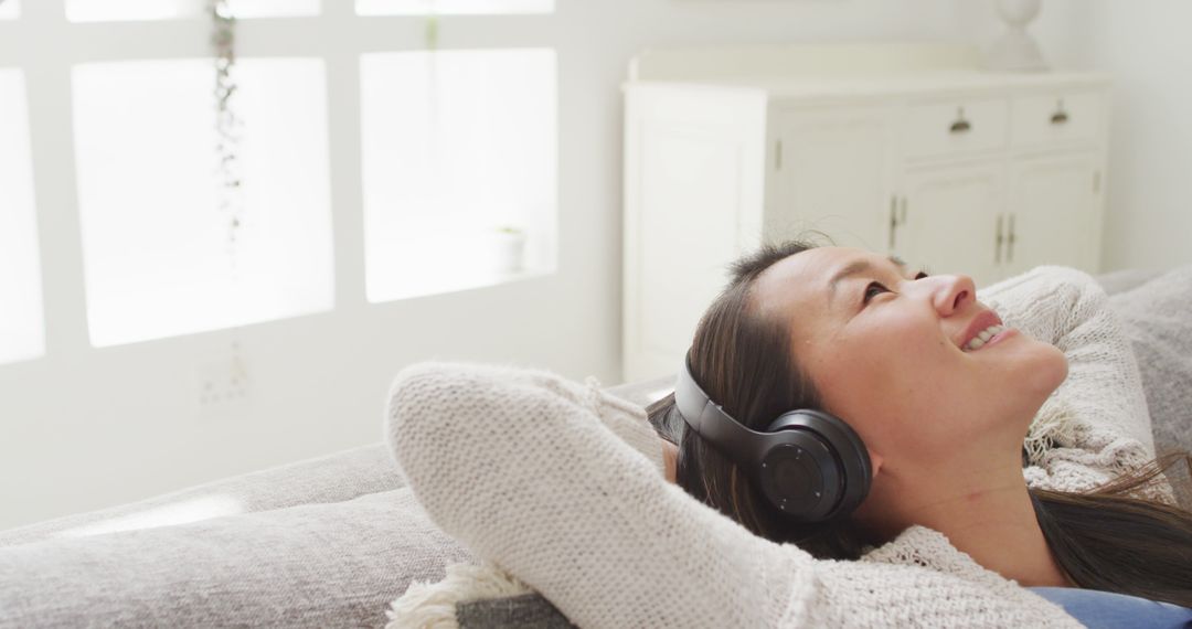 Woman Relaxing at Home Listening to Music with Headphones - Free Images, Stock Photos and Pictures on Pikwizard.com