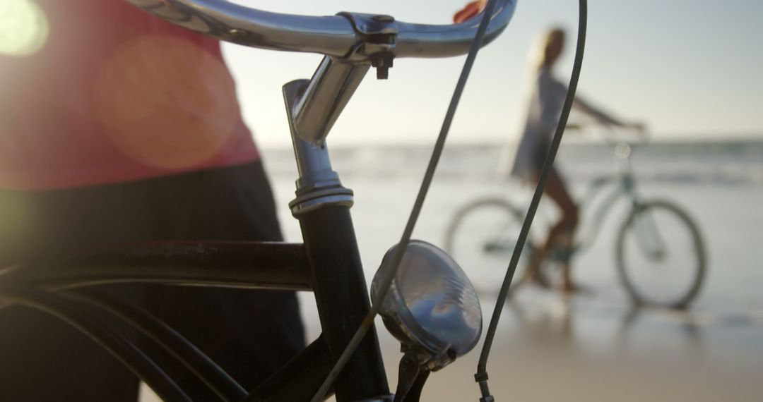 Close-Up of Bicycle at Beach with Person on Background - Free Images, Stock Photos and Pictures on Pikwizard.com