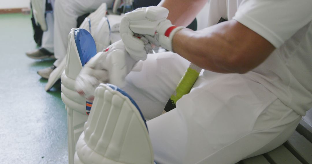 Cricketer Adjusting Gloves in Locker Room Before Match - Free Images, Stock Photos and Pictures on Pikwizard.com