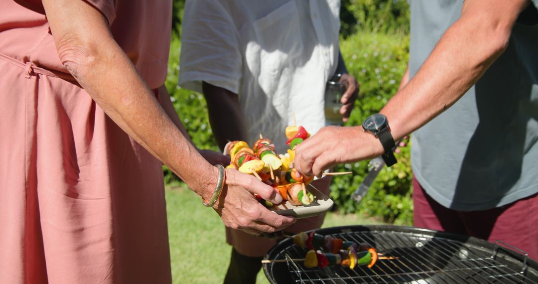 Friends Grilling Skewers Outdoors in Backyard Garden