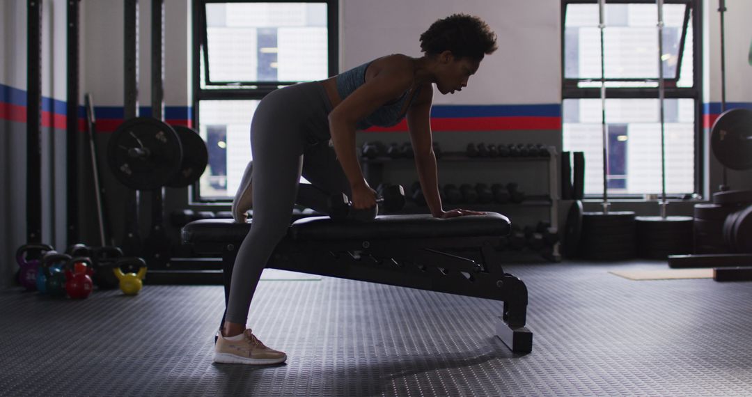 Woman Performing Dumbbell Row in Modern Gym - Free Images, Stock Photos and Pictures on Pikwizard.com