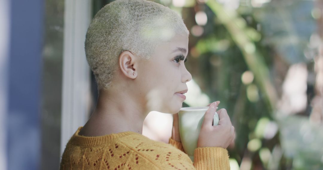 Thoughtful Woman with Short Blonde Hair Sipping Coffee by Window - Free Images, Stock Photos and Pictures on Pikwizard.com