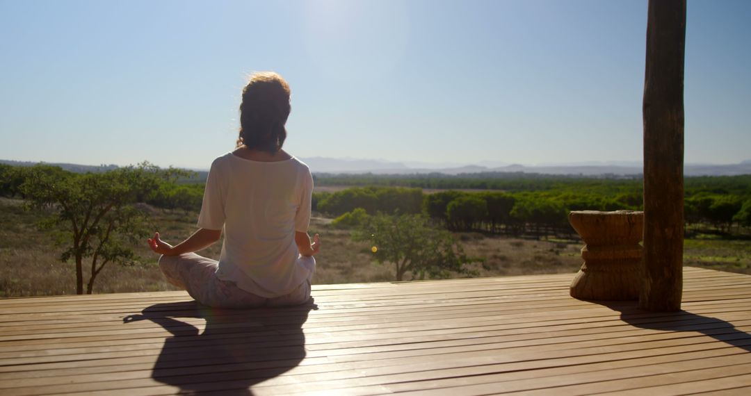 Woman Meditating on Wooden Deck with Scenic View - Free Images, Stock Photos and Pictures on Pikwizard.com