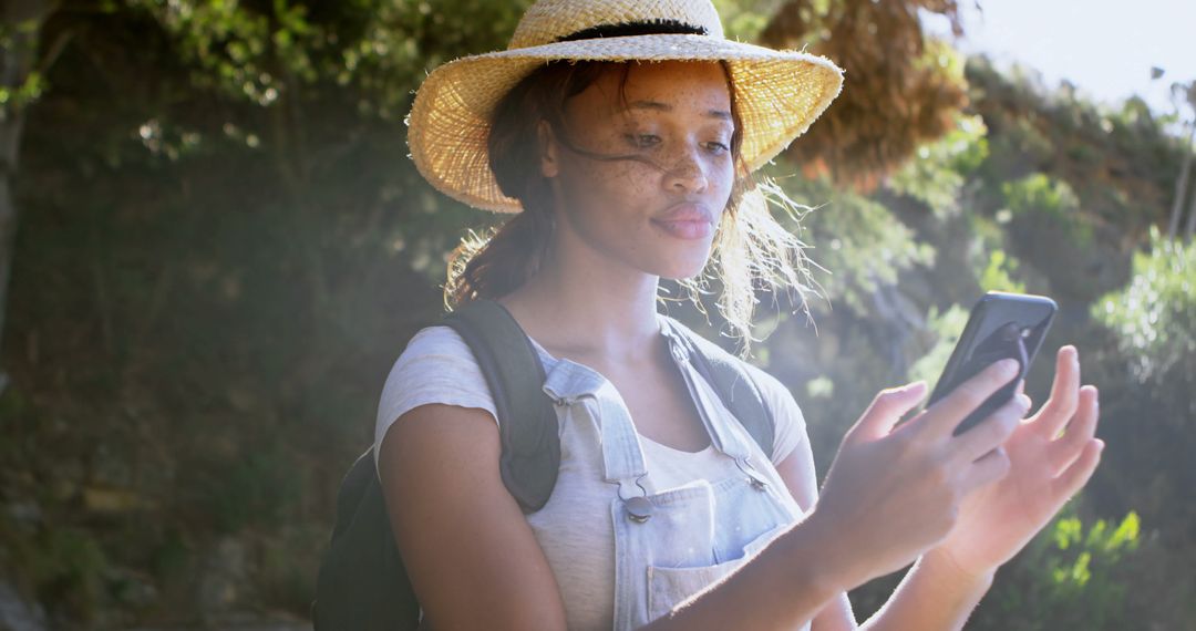 Young African American woman checks her phone outdoor - Free Images, Stock Photos and Pictures on Pikwizard.com