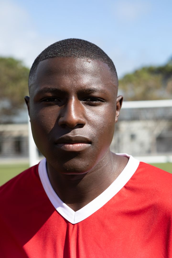 Focus Determined Soccer Player in Red and White Jersey on Sunny Field