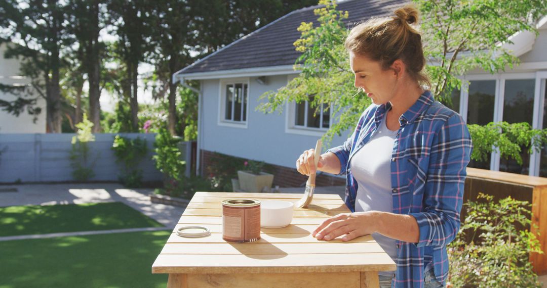 Woman Painting Wooden Furniture Outdoors on a Sunny Day - Free Images, Stock Photos and Pictures on Pikwizard.com