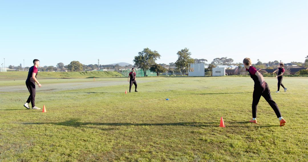 Athletes Practicing Throwing Techniques on Grass Field