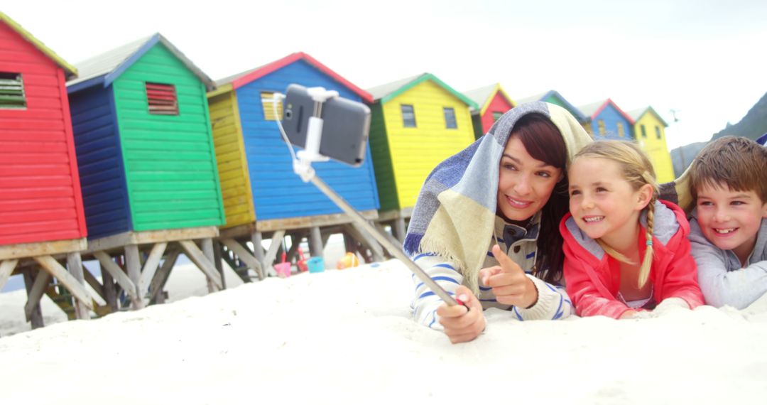 Mother and Children Taking Selfie at Vibrantly Colored Beach Huts - Free Images, Stock Photos and Pictures on Pikwizard.com