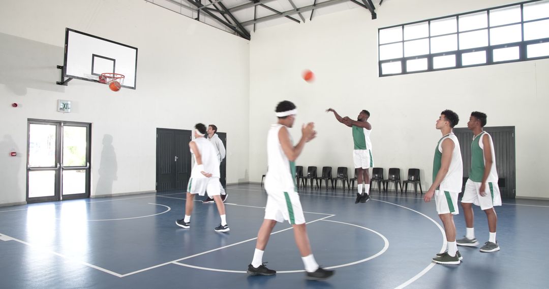 Diverse Male Basketball Team Practicing Jump Shots in Gym