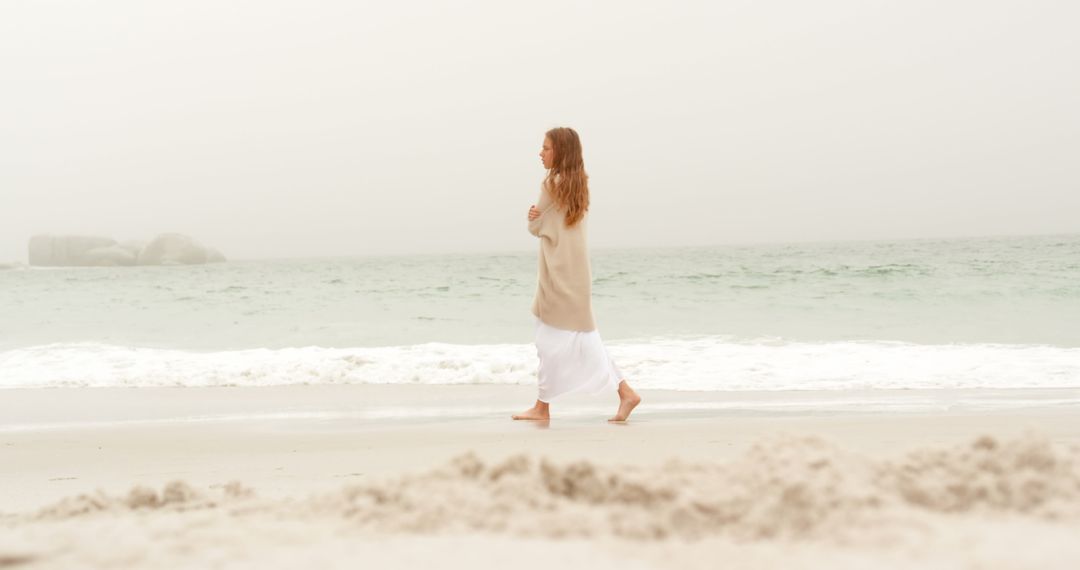 Serene Beach Stroll by Woman in Warm Attire