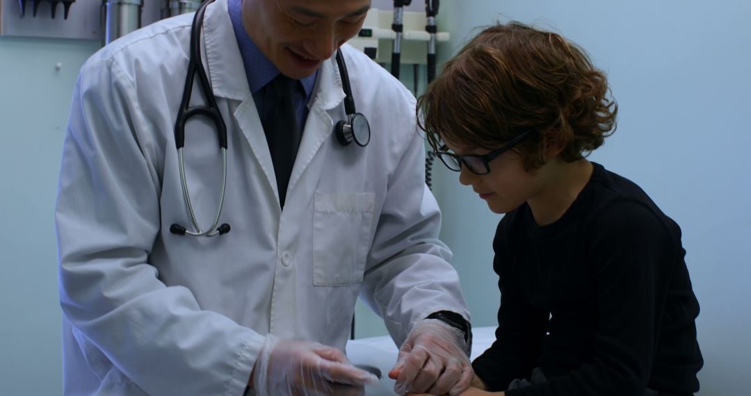 Friendly Doctor Examining Child's Hand in Medical Clinic - Free Images, Stock Photos and Pictures on Pikwizard.com