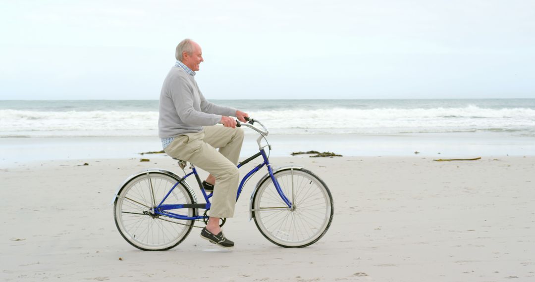 Senior Man Riding Bicycle on Coastal Beach - Free Images, Stock Photos and Pictures on Pikwizard.com