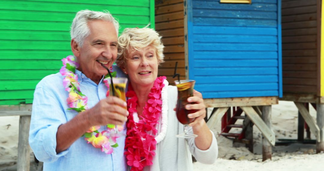 Senior Couple Enjoying Tropical Drinks at Beach Hut - Free Images, Stock Photos and Pictures on Pikwizard.com