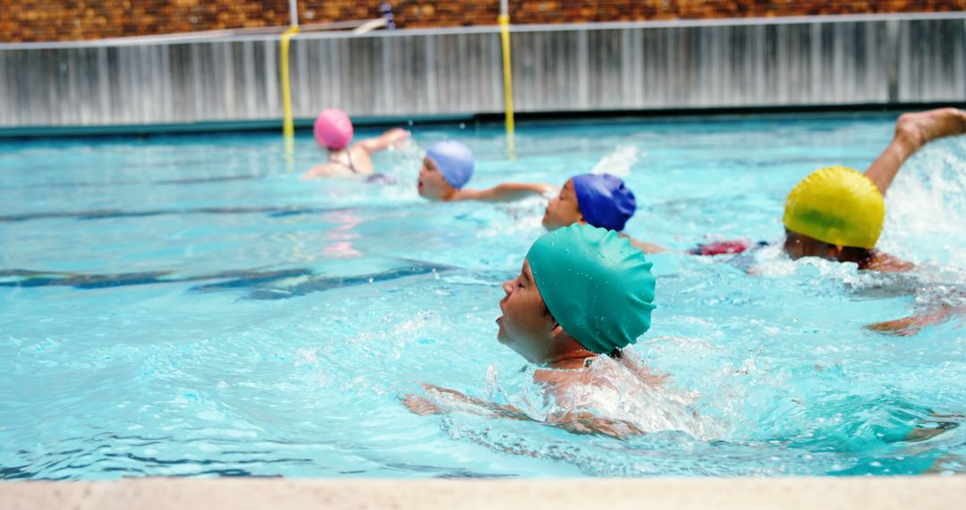 Children Practicing Swimming in Indoor Pool with Colorful Caps - Free Images, Stock Photos and Pictures on Pikwizard.com