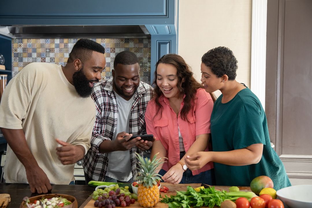 Diverse Friends Enjoy Cooking Session with Smartphone, Smiling Around Kitchen Island