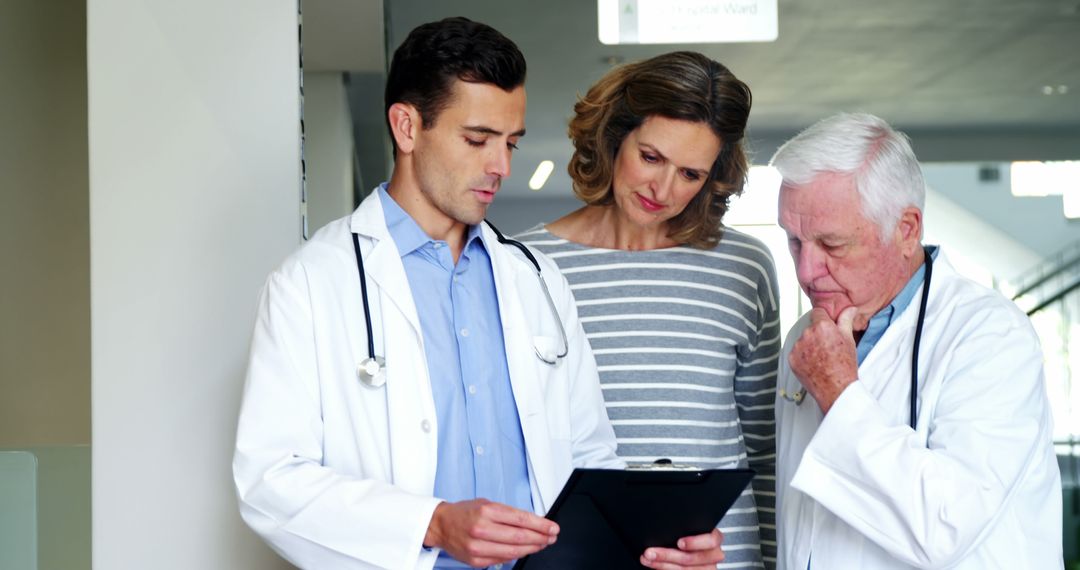 Doctors Discussing Medical Report with Patient in Hospital - Free Images, Stock Photos and Pictures on Pikwizard.com