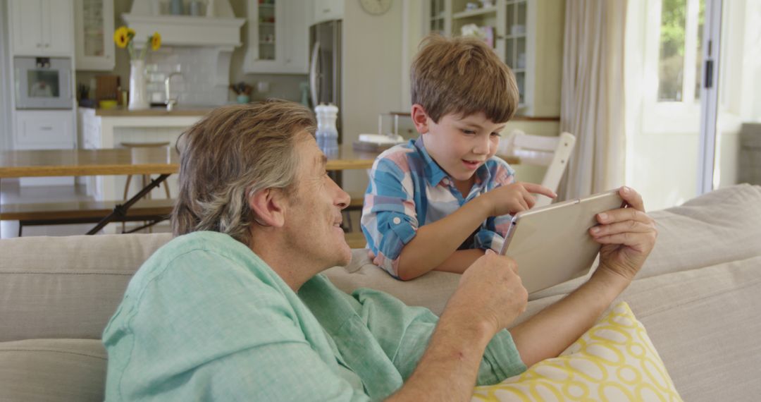 Grandfather and Grandson Using Digital Tablet in Cozy Living Room - Free Images, Stock Photos and Pictures on Pikwizard.com