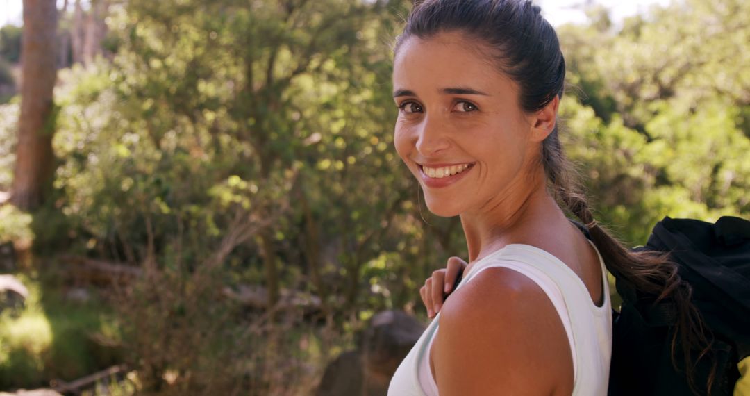 Smiling Woman with Backpack Enjoying Nature at Campsite
