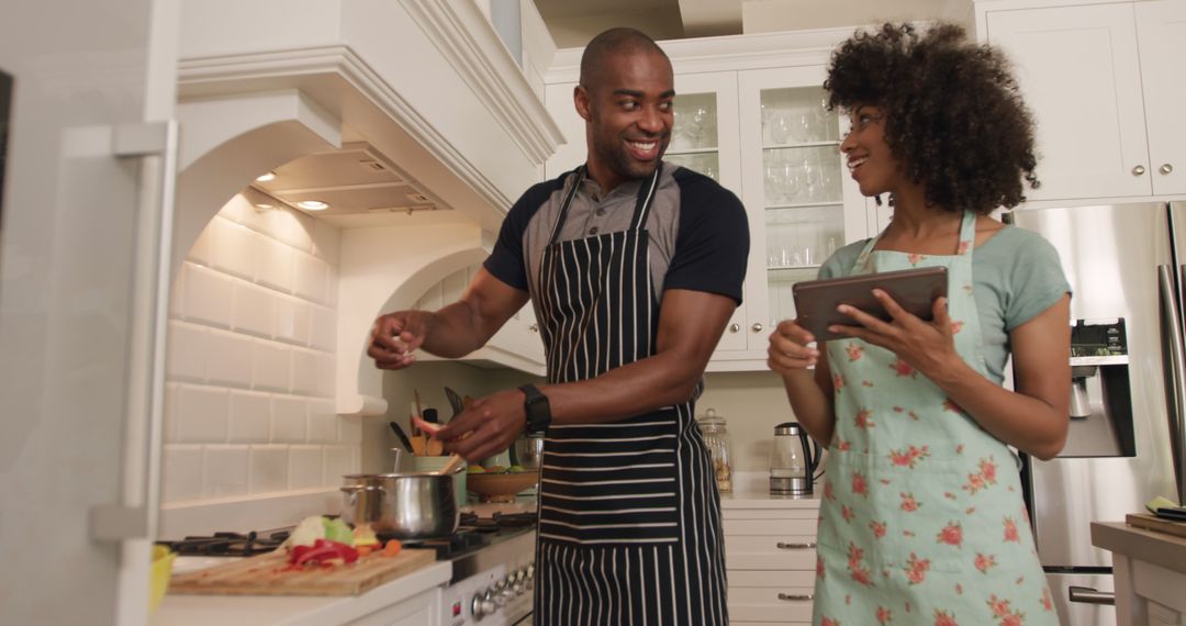 Joyful Couple Cooking Together Using Tablet in Modern Kitchen