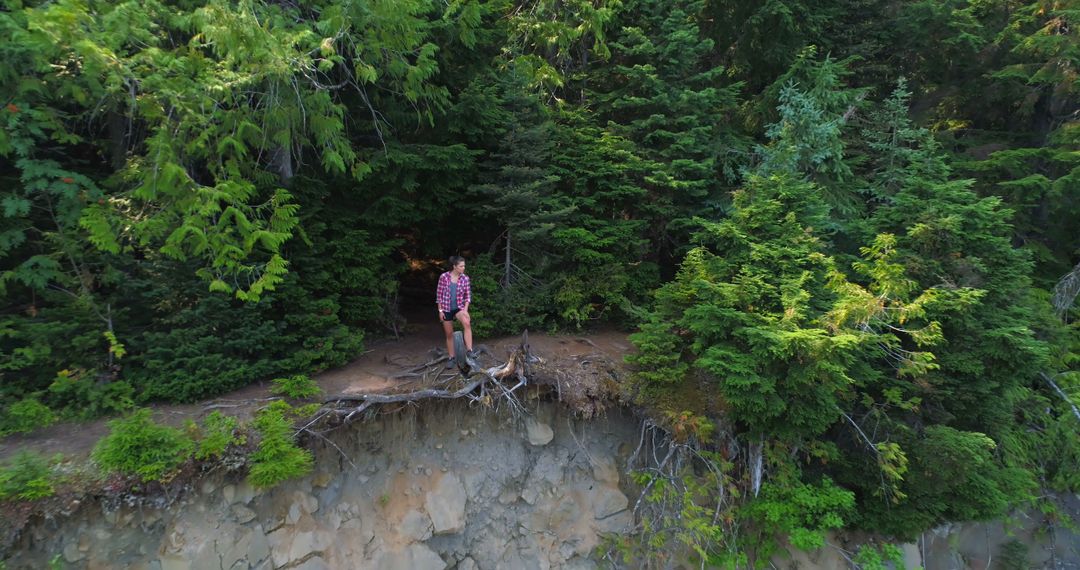 Adventurous Woman Standing on Forest Cliff Edge