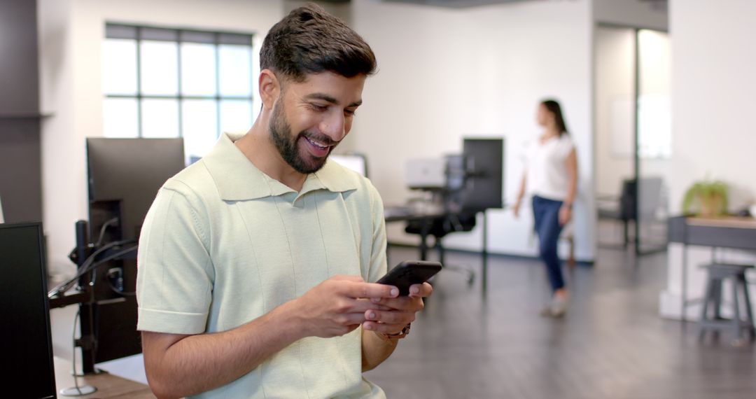 Smiling Professional Using Smartphone in Open Office Environment