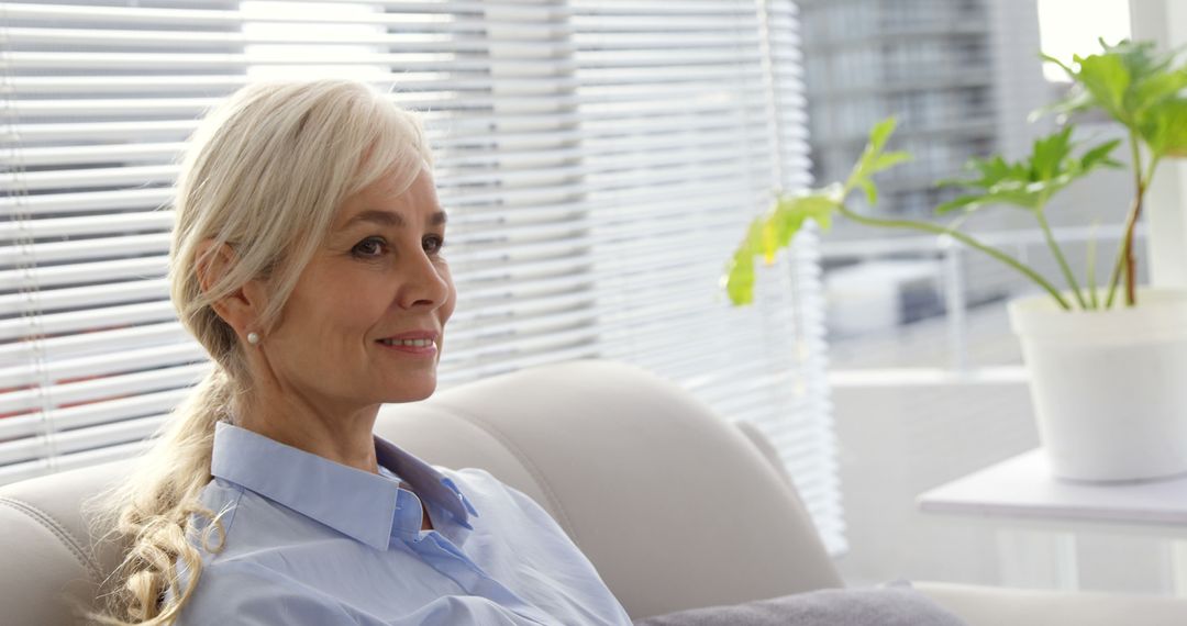 Middle-aged Woman Relaxing in Modern Living Room - Free Images, Stock Photos and Pictures on Pikwizard.com