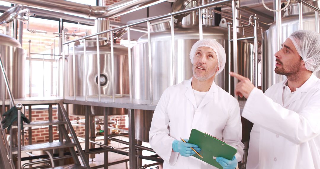 Brewery Workers Collaborating in Modern Brewing Facility - Free Images, Stock Photos and Pictures on Pikwizard.com