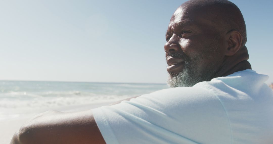 Thoughtful African American Man Reflecting at the Beach on a Sunny Day - Free Images, Stock Photos and Pictures on Pikwizard.com