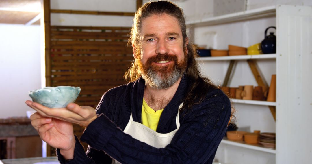 Experienced Potter Displaying Handmade Ceramic Bowl in Studio - Free Images, Stock Photos and Pictures on Pikwizard.com