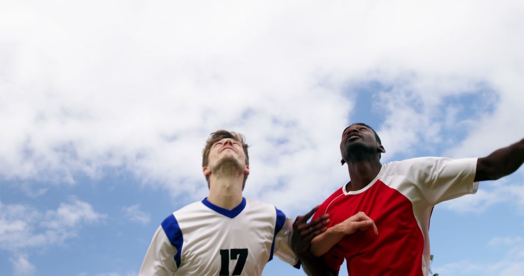 Two Soccer Players Competing for the Ball Under Clear Sky - Free Images, Stock Photos and Pictures on Pikwizard.com