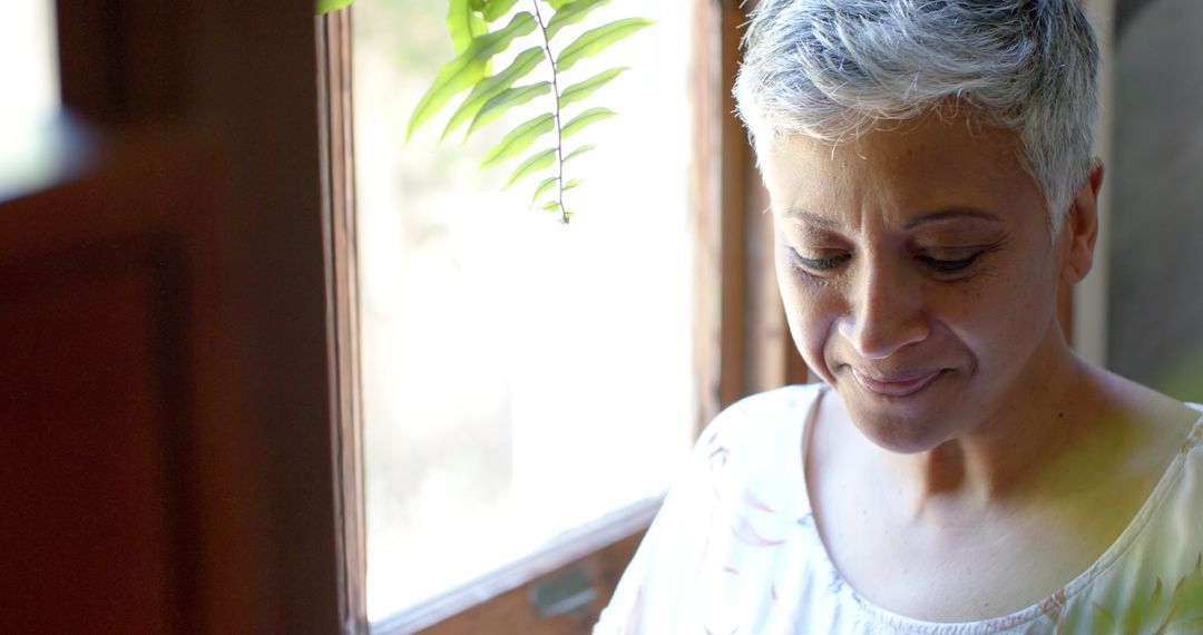 Senior Woman Relaxing with Tea by a Bright Window at Home
