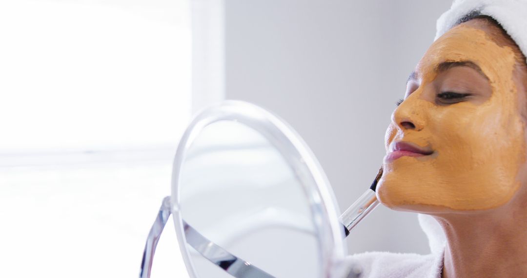 Woman Applying Face Mask in front of Mirror - Free Images, Stock Photos and Pictures on Pikwizard.com