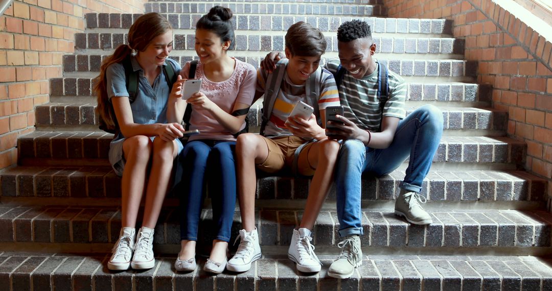 Happy Teenagers Sitting on Steps Using Smartphones - Free Images, Stock Photos and Pictures on Pikwizard.com