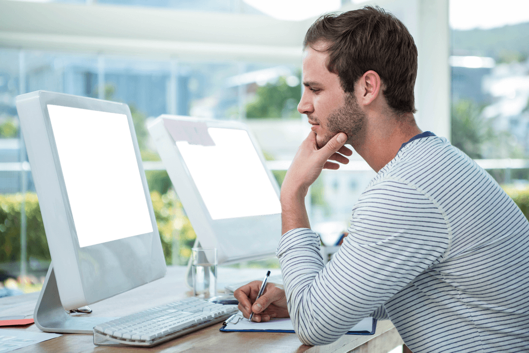 Man Concentrating at Desk with Transparent Dual Monitors