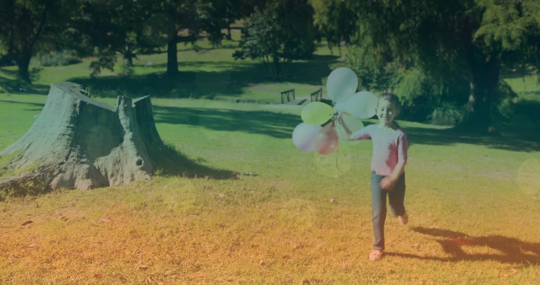 Joyful Child Running in Sunlit Park with Colorful Balloons