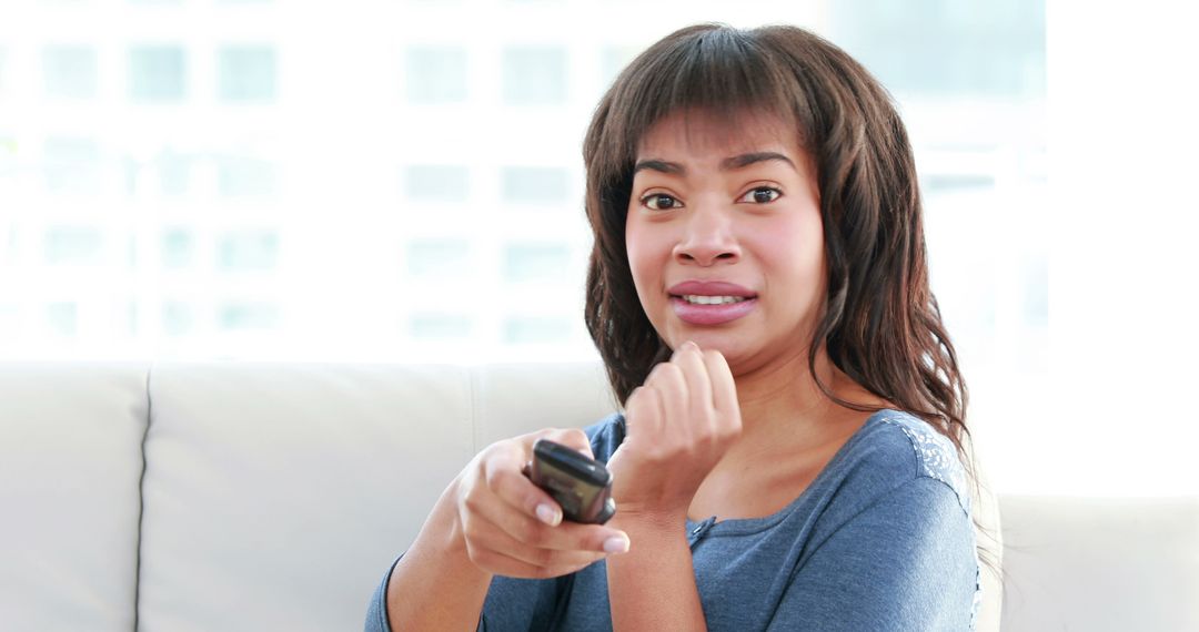 Worried Woman Watching Television Holding Remote Control - Free Images, Stock Photos and Pictures on Pikwizard.com