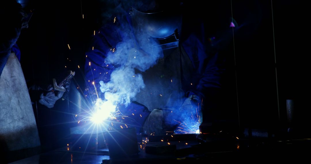 Skilled Welder Working in Dark Workshop with Bright Sparks and Smoke - Free Images, Stock Photos and Pictures on Pikwizard.com